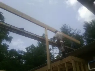 Carpenter setting a ridge beam over a new addition frame — Ice Dam Removal by Roofing Brothers in Dendron