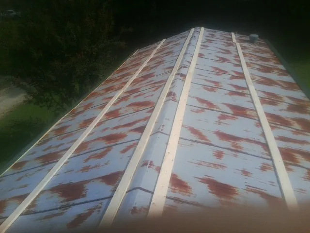 Rusted metal roof panels with new wood purlins before replacement — Storm Damage Roof Repair in Dendron by Roofing Brothers