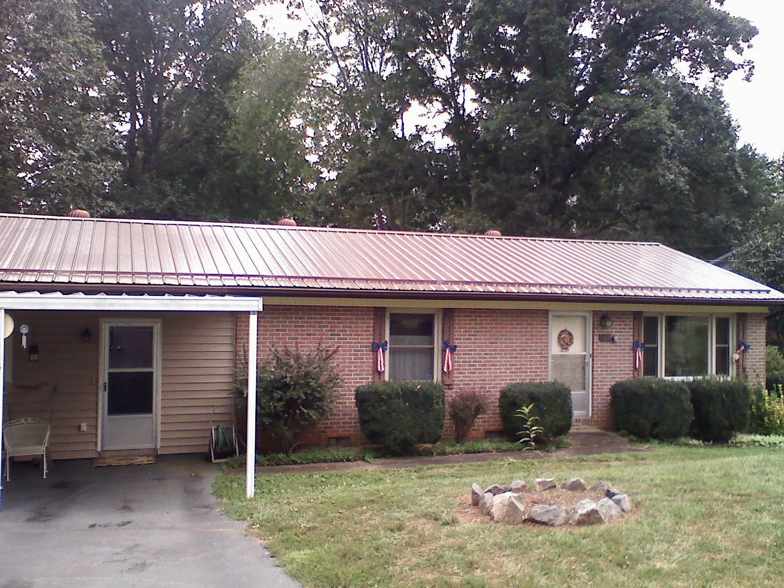 Bronze metal roof and carport on a brick ranch home — Roof Repair work by our crew in Dendron